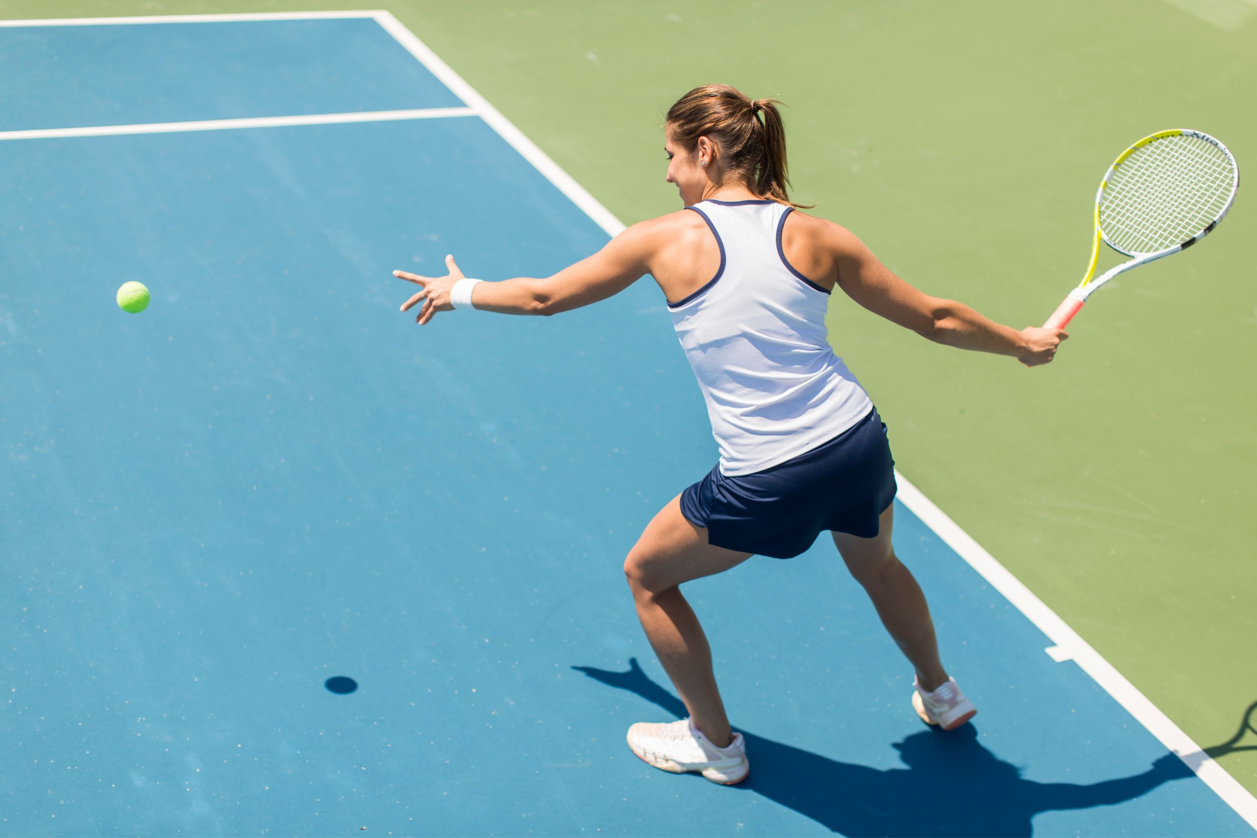 A young, happy woman playing tennis